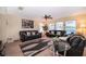 Inviting living room with black leather sofas, ceiling fan, and large windows providing natural light at 133 Rona Ln, Davenport, FL 33897