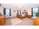 Bright main bedroom with a wood bed, neutral carpet, and sitting chair at 133 Rona Ln, Davenport, FL 33897