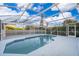 Relaxing screened-in pool area with clear blue pool, comfortable seating, and lush landscaping at 133 Rona Ln, Davenport, FL 33897