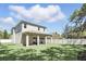 A home's backyard features a well-manicured lawn, a covered patio, and a white fence at 1436 Stetson St, Orlando, FL 32804