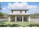 Back exterior view featuring a covered patio, tall green lawn, and white fence at 1436 Stetson St, Orlando, FL 32804