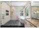 A spacious bathroom featuring a glass shower, soaking tub, marble countertops, and modern fixtures at 1436 Stetson St, Orlando, FL 32804