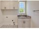 Laundry room featuring sink with granite countertops and modern cabinets at 1436 Stetson St, Orlando, FL 32804