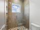 Walk in shower with glass door, overhead shower head, patterned tiles, and a built in seat at 1436 Stetson St, Orlando, FL 32804