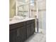 Well-lit bathroom with double sinks, and a glass-enclosed shower featuring tiled walls at 1672 Tropical Palms Cir, Kissimmee, FL 34747