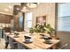 Elegant dining area featuring a large wooden table, modern light fixtures, and natural light at 1672 Tropical Palms Cir, Kissimmee, FL 34747