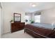 Relaxing bedroom featuring a large bed, dresser with mirror, and bright, sunny windows at 2173 Victoria Dr, Davenport, FL 33837