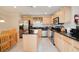 Well-lit kitchen with stainless steel appliances, light wood cabinets, and center island at 2173 Victoria Dr, Davenport, FL 33837