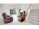 Bright living room featuring high ceilings, staircase, tile flooring and comfortable leather seating at 2173 Victoria Dr, Davenport, FL 33837