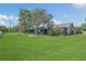 View of backyard with lush green grass, mature trees, and the back of the townhome at 2435 King Oak Ln, St Cloud, FL 34769