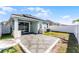 The fenced backyard features a gray tiled patio, a well-maintained lawn, and solar panels on the roof at 2524 Rapollo Dr, Kissimmee, FL 34741