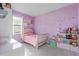 Colorful bedroom with pink decor and a large window, creating a vibrant and cheerful space at 2524 Rapollo Dr, Kissimmee, FL 34741