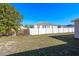 Backyard showcasing a well-maintained white fence, lush green grass, and mature trees at 258 Grouper Ct, Kissimmee, FL 34759