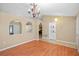 Open-concept living area with wood floors, decorative chandelier, arches, and view into the kitchen area at 258 Grouper Ct, Kissimmee, FL 34759