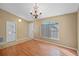 Bright living room with light wood flooring, a decorative chandelier, and a large window with natural light at 258 Grouper Ct, Kissimmee, FL 34759