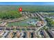 Aerial view of Regal Oaks community featuring townhomes, resort pool, ponds, lush greenery, and amenities at 2621 Corvette Lane, Kissimmee, FL 34746