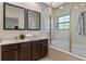 Bathroom featuring double sinks, a glass enclosed shower, and bright, modern design at 2621 Corvette Lane, Kissimmee, FL 34746