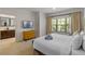 Bright bedroom featuring a plush king bed, flatscreen tv, and view of exterior landscaping at 2621 Corvette Lane, Kissimmee, FL 34746
