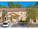 Townhome featuring a terra cotta roof, paver driveway, and lush tropical landscaping at 2621 Corvette Lane, Kissimmee, FL 34746