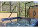 Luxurious hot tub inside a screened patio, surrounded by lush greenery, offering privacy and relaxation at 2621 Corvette Lane, Kissimmee, FL 34746