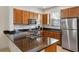 Modern kitchen features granite countertops, stainless steel appliances, and wooden cabinetry at 2621 Corvette Lane, Kissimmee, FL 34746