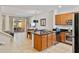 Modern kitchen featuring an island with granite countertops and seamless flow to dining area at 2621 Corvette Lane, Kissimmee, FL 34746