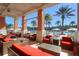 Relax on the covered patio near the pool, featuring comfortable seating and views of palm trees and the sparkling pool at 2621 Corvette Lane, Kissimmee, FL 34746