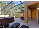 Outdoor patio featuring a screened-in enclosure, hot tub, and dining area at 2621 Corvette Lane, Kissimmee, FL 34746