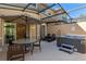 Relaxing screened patio featuring a hot tub, lounge chairs, and an umbrella-covered dining table at 2621 Corvette Lane, Kissimmee, FL 34746