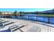 Relax on the pool deck with lounge chairs overlooking the tranquil lake, creating a perfect spot for rest and relaxation at 2621 Corvette Lane, Kissimmee, FL 34746