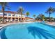 View of a resort-style pool with palm trees, umbrellas, and lounge chairs for community residents at 2621 Corvette Lane, Kissimmee, FL 34746