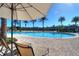 View of a resort-style pool with lounge chairs and palm trees for community residents at 2621 Corvette Lane, Kissimmee, FL 34746