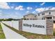 A view of the Hilltop Estates community sign with attractive landscaping under a partly cloudy sky at 280 Hilltop Bloom Loop, Haines City, FL 33844