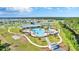 Aerial view of community pool with water park, clubhouse, and plenty of seating at 2879 Common Crane Ct, Harmony, FL 34773