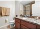 This bathroom features a wood vanity, granite countertop and a shower with a patterned shower curtain at 2920 Windmill Dr, Kissimmee, FL 34741