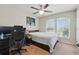 This is a bedroom featuring a desk, a modern ceiling fan, carpeted floors and two windows at 2920 Windmill Dr, Kissimmee, FL 34741