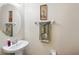 Tastefully decorated half-bathroom with a pedestal sink, decorative mirror, and charming accents at 2920 Windmill Dr, Kissimmee, FL 34741