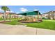 Community playground under a shaded canopy, featuring play structures and a bench, surrounded by residential homes at 2920 Windmill Dr, Kissimmee, FL 34741