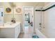 Bright bathroom with white vanity, toilet, tub, and doorway view of the bedroom at 2958 Sunset Vista Blvd, Kissimmee, FL 34747