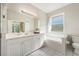 Bright bathroom with a soaking tub, white cabinetry, and a window providing natural light at 2958 Sunset Vista Blvd, Kissimmee, FL 34747