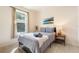 Cozy bedroom featuring a bed with linens, a side table, a neutral color palette, and a sunlit window at 2958 Sunset Vista Blvd, Kissimmee, FL 34747