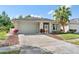 Lovely home showcasing a manicured lawn, mature landscaping, and a spacious driveway at 2958 Sunset Vista Blvd, Kissimmee, FL 34747