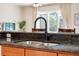 Close-up of the kitchen sink and counter, highlighting the black granite and modern faucet at 2958 Sunset Vista Blvd, Kissimmee, FL 34747