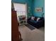 Cozy bedroom featuring blue walls, a comfortable loveseat, and natural light from a large window at 4032 Bougainvillea Pl, Kissimmee, FL 34746