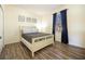 Bedroom featuring a white bedframe with a patterned comforter, and blue curtains framing the window at 561 Las Fuentes Dr, Kissimmee, FL 34747