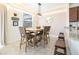 Charming dining area with a modern light fixture and an adjacent kitchen counter with stools at 561 Las Fuentes Dr, Kissimmee, FL 34747