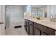 Bathroom with double sink vanity, a soaking tub, and a glass-enclosed shower at 624 Sardinia Circle, Davenport, FL 33837