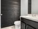 Half bathroom features a wood accent wall, toilet, and cabinet with sink at 624 Sardinia Circle, Davenport, FL 33837