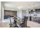 Open concept kitchen and living area with modern dining table and rustic wood accent wall with a black sofa at 624 Sardinia Circle, Davenport, FL 33837