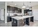 Bright kitchen featuring a large center island with counter seating, modern stainless steel appliances, and dark cabinetry at 624 Sardinia Circle, Davenport, FL 33837